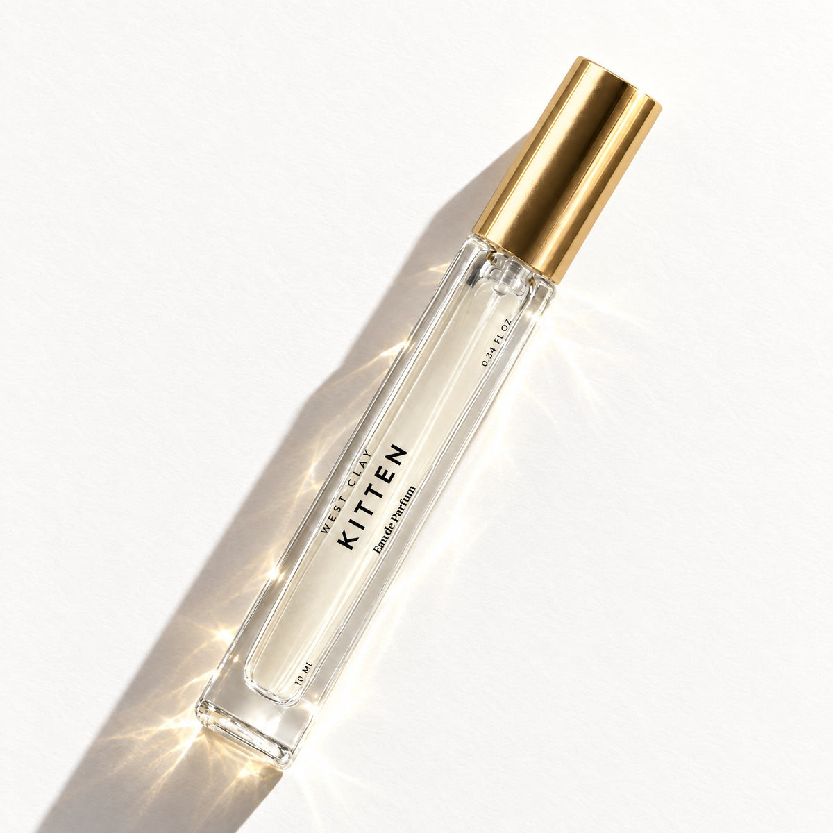 Kitten Eau de Parfum by West Clay, 10 mL travel size flash flat lay studio photo