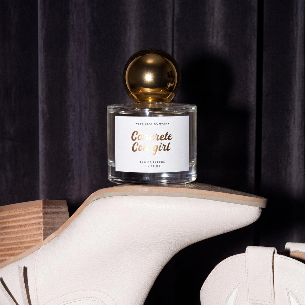 Concrete Cowgirl Eau de Parfum bottle perched on a white cowboy boot